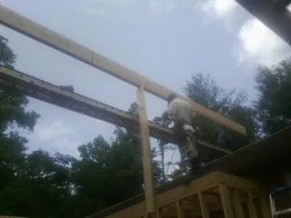 Carpenter setting a ridge beam over a new addition frame — Ice Dam Removal by Roofing Brothers in Virden