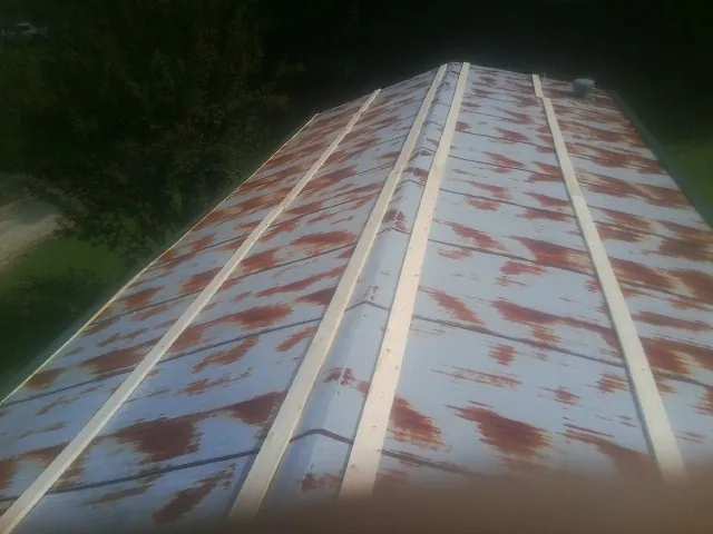 Rusted metal roof panels with new wood purlins before replacement — Storm Damage Roof Repair in Virden by Roofing Brothers